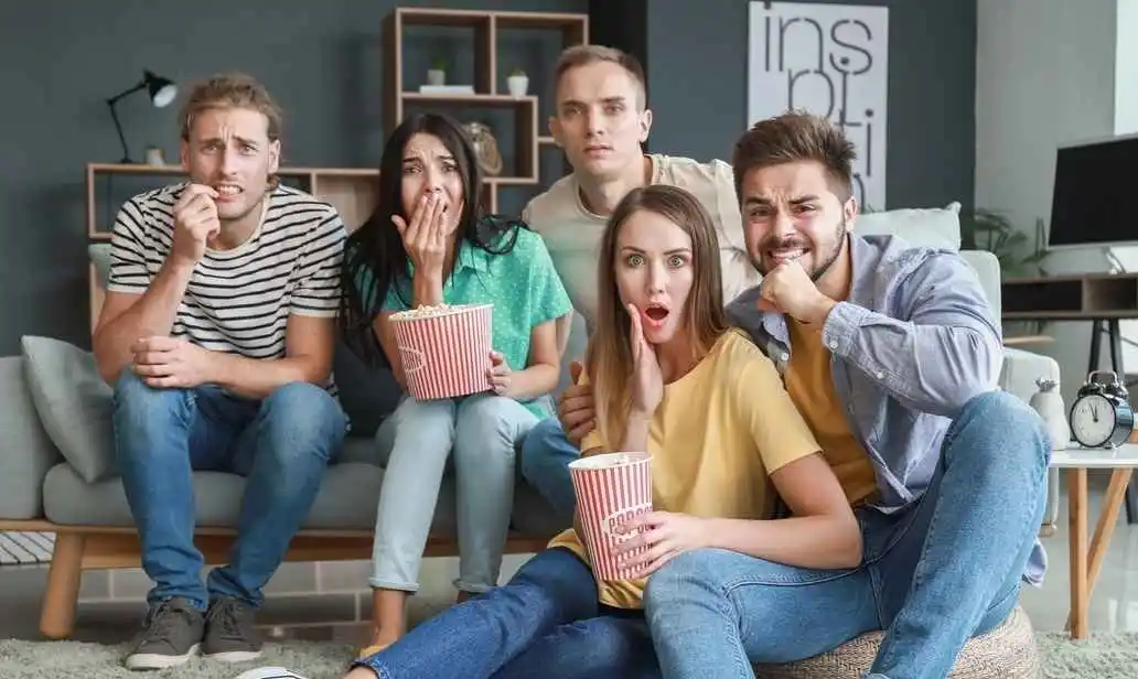 Amigos reunidos no sofá assistindo à televisão